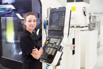 Portrait Of Female Engineer Operating CNC Machinery
