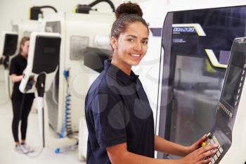 Portrait Of Female Engineer Operating CNC Machinery