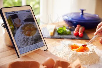 Person Following Pasta Recipe Using App On Digital Tablet
