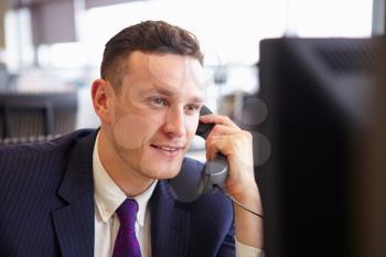 Head and shoulders of a young businessman, using telephone
