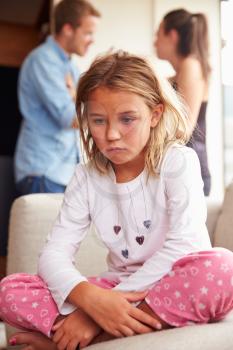 Unhappy Girl At Home With Parents Arguing In Background