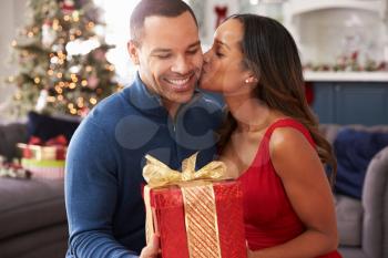 Romantic Couple Exchanging Christmas Gifts At Home