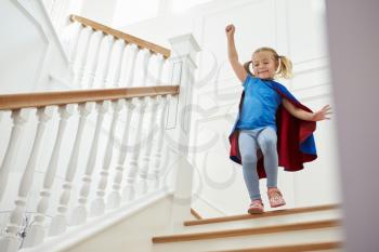 Girl Dressed Up As Superhero Playing Game On Stairs