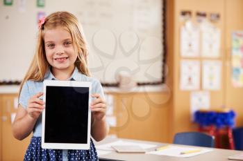 Elementary school girl holding a tablet computer, portrait
