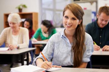 Young woman at an adult education class looking to camera
