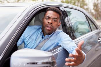 Frustrated African American male driver in car