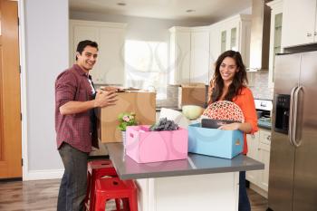 Portrait Of Young Couple Moving In To New Home Together