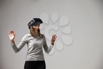 Young Woman Wearing Virtual Reality Headset In Studio