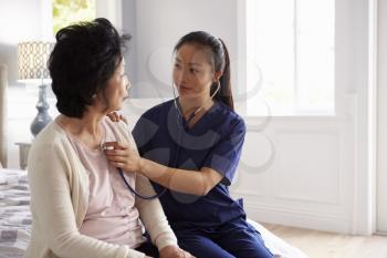 Nurse Making Home Visit To Senior Woman For Medical Exam