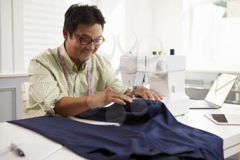 Man Making Clothes Using Sewing Machine At Home