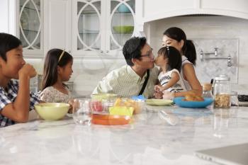 Father Leaving For Work After Family Breakfast In Kitchen