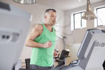 Mature Man Running On Treadmill In Gym