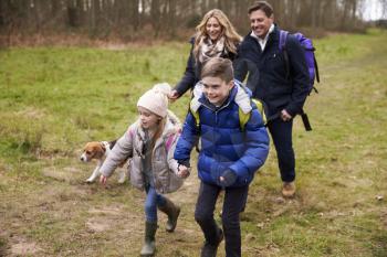 Happy family walking in the countryside with their dog