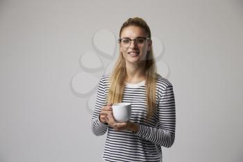 Studio Portrait Of Young Businesswoman Drinking Coffee