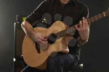 Close Up Of Man Playing Amplified Acoustic Guitar