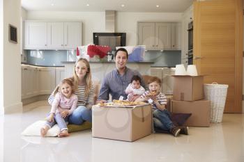 Family Celebrating Moving Into New Home With Pizza