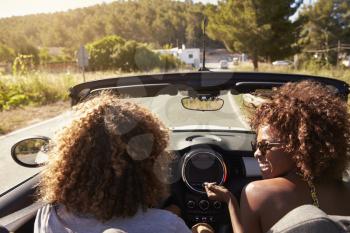 Happy young couple driving in an open top car, Ibiza, Spain