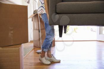 Close Up Of Woman Carrying Sofa Into New Home On Moving Day