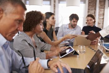 Businesspeople Meeting Around Table In Modern Office