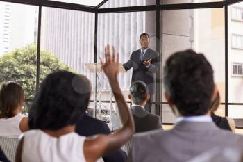 Black businessman giving seminar takes audience questions