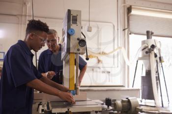 Carpenter Training Male Apprentice To Use Mechanized Saw
