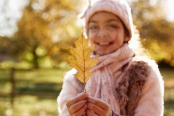 Outdoor Portrait Of Girl Holding Autumn Leaf