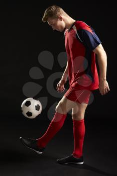 Professional Soccer Player Controlling Ball In Studio