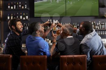 Rear View Of Male Friends Relaxing In Bar Together