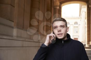 Young Man Talking On Mobile Phone In City Setting