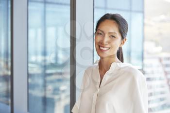 Portrait Of Businesswoman Standing By Window In Office