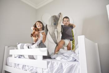 Portrait Of Children Playing With Toys In Bunk Bed