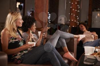 Three friends enjoy girls night in with a Chinese take-away