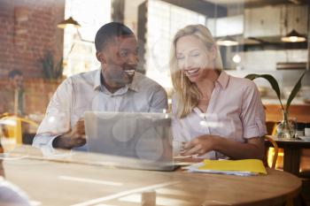 Two Businesspeople Meet In Coffee Shop Shot Through Window
