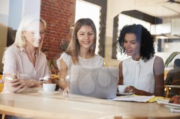 Three Businesswomen Meet In Coffee Shop Shot Through Window
