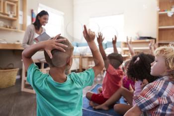 Pupils At Montessori School Raising Hands To Answer Question