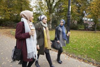 Group Of British Muslim Women Friends Walking Through Park