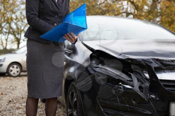 Female Loss Adjuster Writing Report On Damaged Car