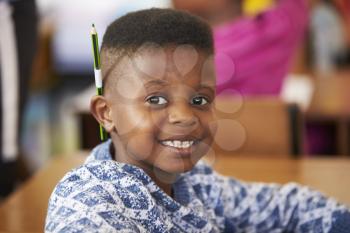 Boy smiling to camera in an elementary school lesson