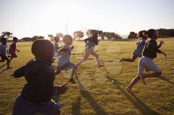 Elementary school boys and girls running in an open field