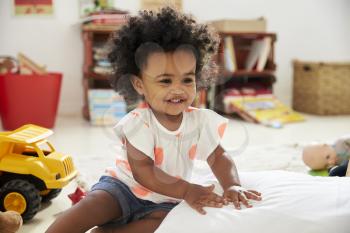 Happy Baby Girl Playing With Toys In Playroom
