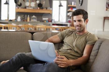 Man Sitting On Lounge Sofa Using Laptop