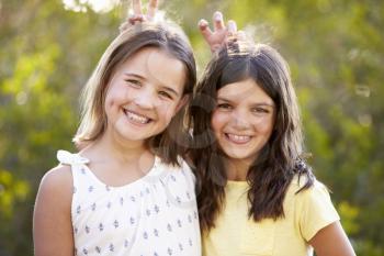 Portrait of two smiling young girls have posing to camera