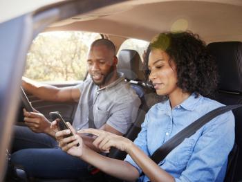 Young black couple navigating with smartphone on a road trip