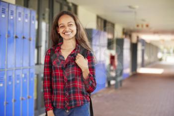 Happy white teenage girl smiling in high school corridor