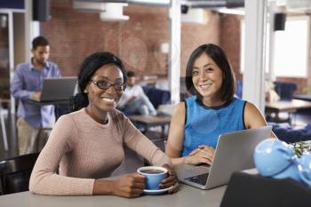Two Businesswomen Have Informal Meeting In Office Coffee Bar