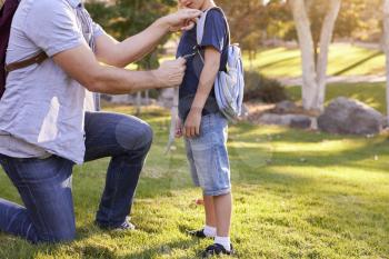 Father Fastening Son's Backpack As They Get Ready For Hike