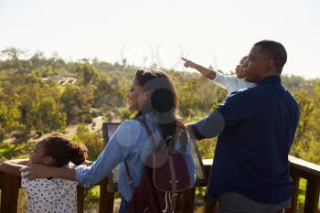 Family Standing On Outdoor Observation Deck Looking At View