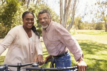 Portrait Of Mature Couple Going For Cycle Ride In Park