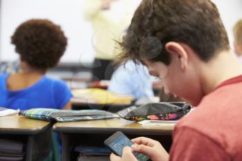 Pupil Playing a Mobile Game On Phone In Class