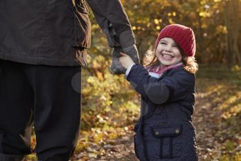 Grandfather And Granddaughter Enjoying Autumn Walk